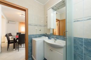 a bathroom with a sink and a toilet and a table at Apartmani Petra in Trogir +27 photos