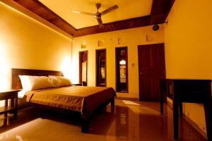a bedroom with a bed and a ceiling fan at Arsuma Guest House in Gianyar +21 photos