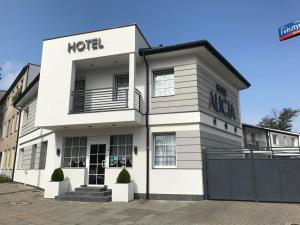 罗兹Hotel Alicja的一座挂着酒店标志的白色建筑