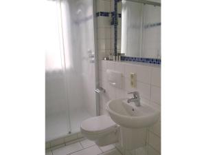 a bathroom with a toilet and a sink at Ferienwohnung Villa im Park in Wangerooge +16 photos