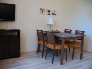a dining room table with chairs and a television at Ferienwohnung Villa im Park in Wangerooge