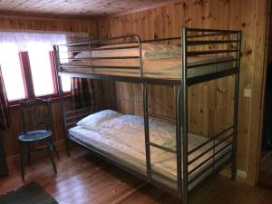 Pokój z łóżkiem piętrowym z 2 łóżkami piętrowymi i krzesłem w obiekcie Løngdal w mieście Tuddal