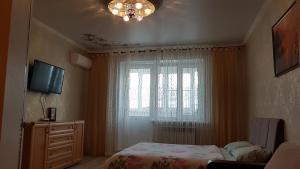 a bedroom with a bed and a window at Apartments Avrora, Gagarina 75 in Oryol