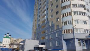 a tall apartment building in front of a building at Apartments Avrora, Gagarina 75 in Oryol