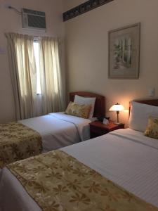 Rúm í herbergi á Hotel Mac Arthur