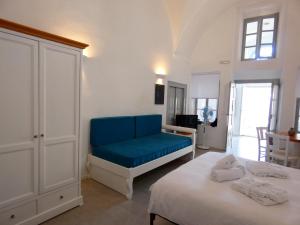 1 dormitorio con 2 camas y sofá azul en Pantelia Pyrgos, en Pirgos