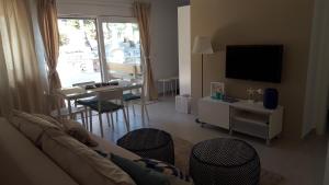 Apartment Rina Deluxe في سيموني: غرفة معيشة مع أريكة وطاولة مع كراسي