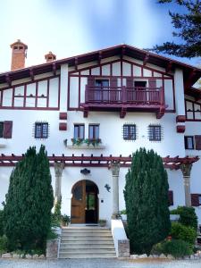 a white house with a balcony and a door at La Villa du Parc in Prades