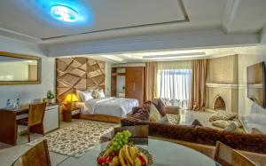 Habitación de hotel con cama y sala de estar. en Yaad City Hotel, en Marrakech