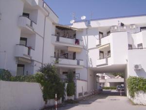 um grande edifício de apartamentos branco com estacionamento em La dolce vita, relax & kite Lamezia em Lamezia Terme