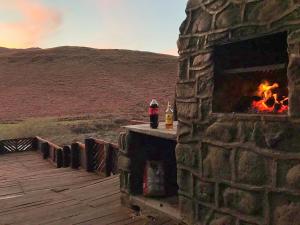 a fireplace on a deck with a fire in it at Amanzi Empilo Bungalow in Rhodes