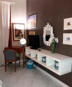 a living room with a desk with a tv and a mirror at Anna Vì Guest Home in Rome