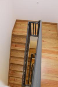 une cage d'escalier avec une balustrade noire et du parquet dans l'établissement Lost Apartments, à Porto
