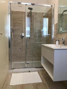 La salle de bains est pourvue d'une douche en verre et d'un lavabo. dans l'établissement La Ghirlanda B&B, à Arezzo