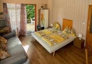 a bedroom with a large bed and a couch at Vadásztanya Apartmanházak in Siófok