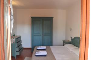 a bedroom with a bed and a blue cabinet at Trilocale Vignola Mare in Aglientu
