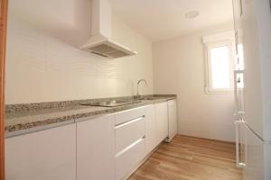 a white kitchen with a sink and a window at OLIVA HOLIDAYS 4 in Oliva +43 photos