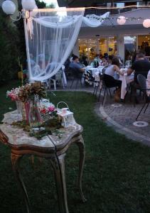 una mesa con flores en ella con gente sentada en las mesas en Hotel Corona, en Riccione