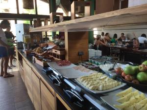 a buffet line with cheese and other food in a restaurant at Charme Comforto Beira Mar in Angra dos Reis