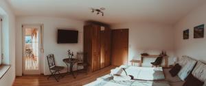 ein Wohnzimmer mit einem Bett und einem TV in der Unterkunft Ferienwohnung Thannen in Lingenau