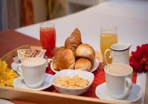 リッチョーネにあるHotel Coronaのテーブルの上に朝食用の食品とドリンクのトレイ