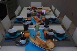 a table with a breakfast of bread and orange juice at Maison Cube in Saint-Didier-au-Mont-dʼOr