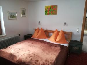ein Schlafzimmer mit einem großen Bett mit orangefarbenen Kissen in der Unterkunft Angela Apartment in Piesendorf