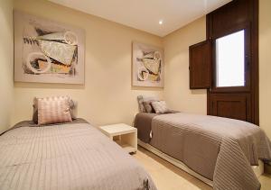 1 dormitorio con 2 camas y ventana en WaterFront Apartment, en Estepona