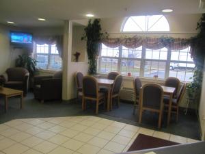a waiting room with tables and chairs and windows at Microtel Inn by Wyndham Champaign in Champaign