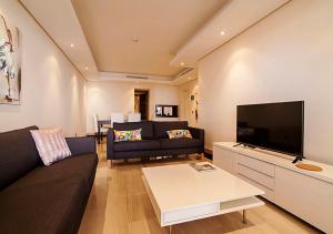 a living room with a couch and a flat screen tv at WaterFront Apartment in Estepona