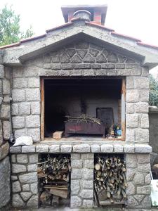 a stone oven with a pile of wood in it at Apartman Tri palme in Gabonjin