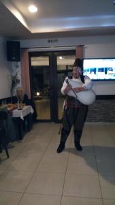 a woman is holding a drum in a restaurant at Hotel Enchevi in Kirkovo