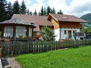 a small house with a wooden fence in a yard at Zimmer im Lungau in Sankt Michael im Lungau