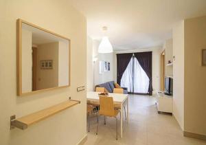 a living room with a table and a mirror at Samara Marbella Apartment in Marbella