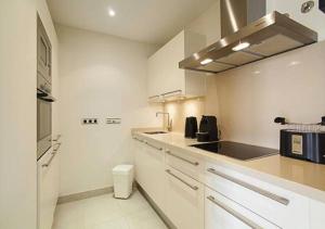 una cucina con armadi bianchi e piano cottura di Samara Marbella Apartment a Marbella
