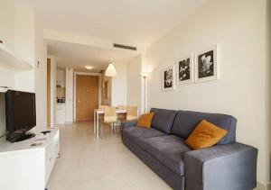 a living room with a couch and a television at Samara Marbella Apartment in Marbella
