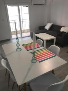 サン・ホアン・デ・アリカンテにあるPlaya Precioso apartamento para familia con niñosのリビングルーム(白いテーブル、椅子付)