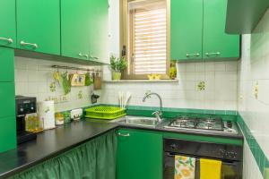 eine grüne Küche mit einer Spüle und einem Herd in der Unterkunft Casa Martina in Giardini-Naxos