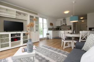 un soggiorno con divano e tavolo e una cucina di Amare Dierhagen a Dierhagen