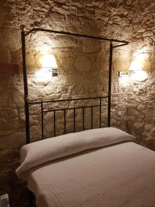 Xenia 2 في Saint Therapon: غرفة نوم مع سرير مع مصباحين على الحائط