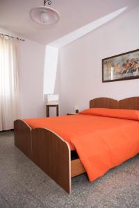 a bedroom with a bed with an orange blanket at Green House in Villaputzu