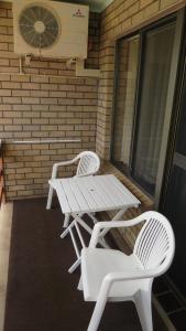 a white chair sitting in front of a window at Beachview Motel - Adults Only in Bermagui