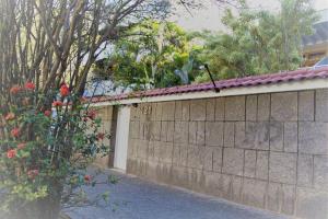 a stone wall with a bush next to a building at REF House Barra Da Tijuca in Rio de Janeiro