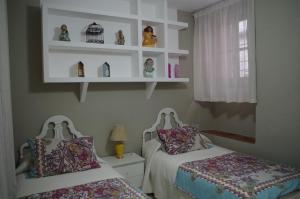 コルドバにあるAlojamiento casa típica de Córdobaのベッドルーム1室(ベッド2台、壁に棚付)