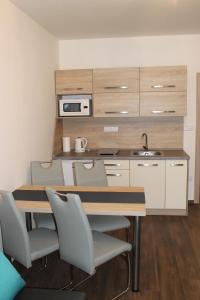 a kitchen with a table and chairs and a sink at Apartment Lúčky - Jasná in Demanovska Dolina
