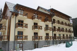 a large building with balconies on it in the snow at Apartment Lúčky - Jasná in Demanovska Dolina