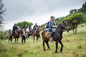 un grupo de personas montando caballos en un campo en Hacienda Historica Marchigue, en Marchihue