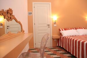 a bedroom with a bed and a mirror and a chair at B&B Casa Ruffino in Balestrate