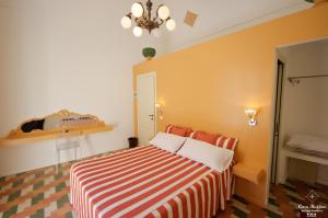 a bedroom with a bed with a striped blanket at B&B Casa Ruffino in Balestrate