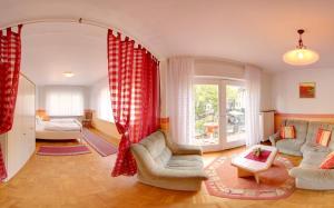 a living room with red curtains and a room with a bed at Hotel Weingut Schützen in Senheim
